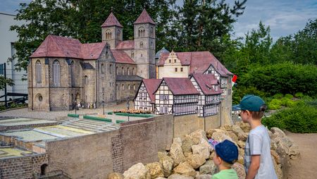 Zwei Kinder stehen vor dem Modell der Stiftskirche in Quedlinburg im Miniaturenpark Kleiner Harz in Wernigerode.